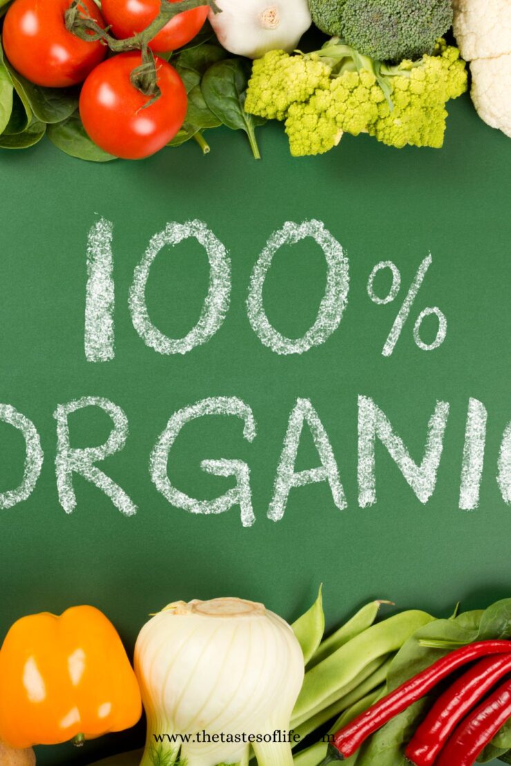 Chalk text 100% ORGANIC on a green background, surrounded by fresh vegetables including tomatoes, broccoli, cauliflower, bell pepper, onion, chili peppers, and green beans.