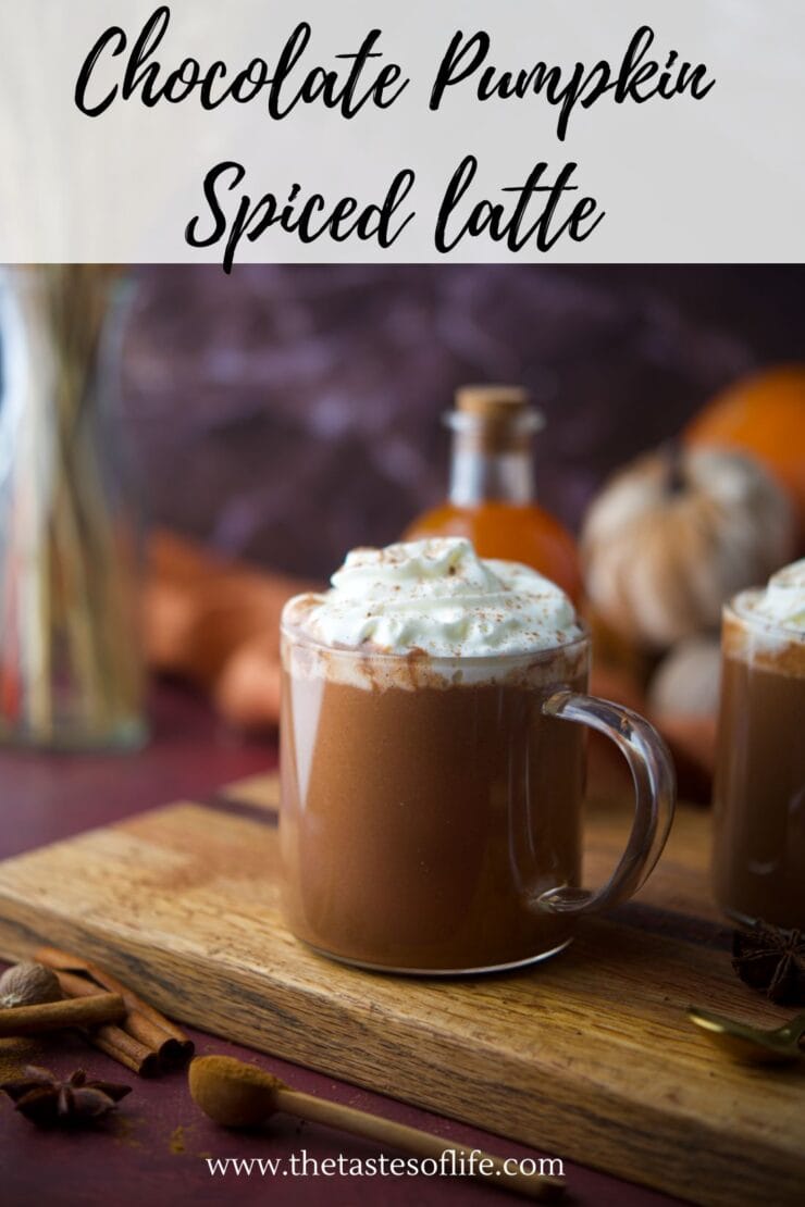 A glass mug of chocolate pumpkin spiced latte topped with whipped cream sits on a wooden board, with spices, a pumpkin, and a garlic bulb in the background. Text above reads &ldquo;Chocolate Pumpkin Spiced latte.&rdquo;.