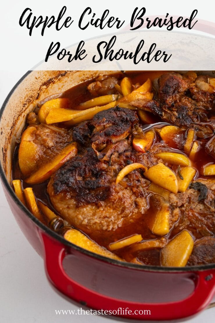 A red Dutch oven filled with apple cider braised pork shoulder, featuring browned meat, apple slices, and a rich, savory sauce. The text reads Apple Cider Braised Pork Shoulder at the top.