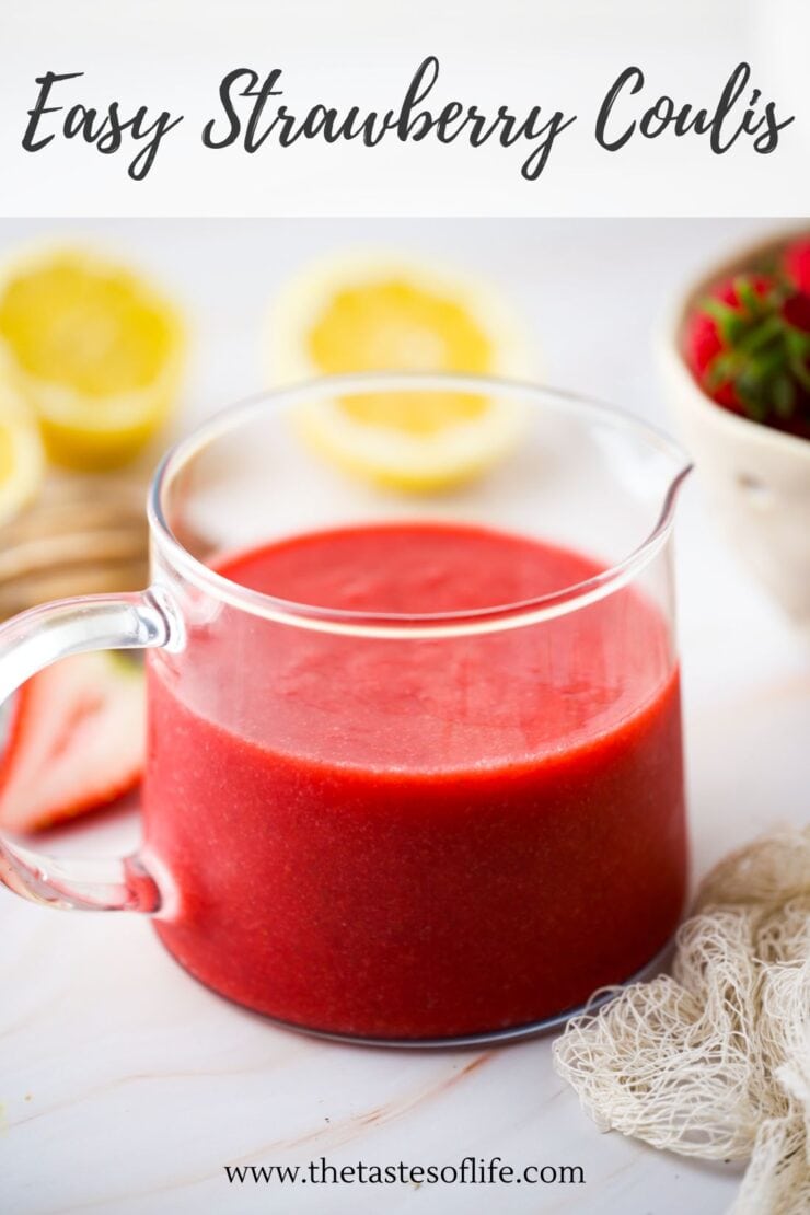 A clear glass pitcher filled with vibrant red strawberry coulis sits on a white surface, with lemon halves and a bowl of strawberries blurred in the background. Text at the top reads Easy Strawberry Coulis.