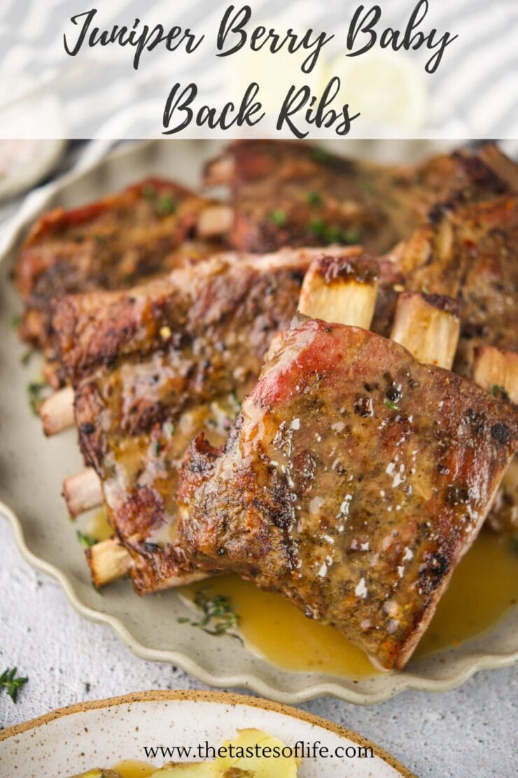 A plate of juicy, seasoned juniper berry baby back ribs garnished with herbs, served on a light-colored plate with sauce. Text on the image reads Juniper Berry Baby Back Ribs and includes a website URL at the bottom.
