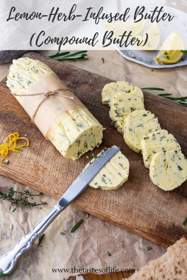 A log of lemon-herb-infused compound butter is sliced on a wooden board with a knife. Fresh herbs, lemon zest, and cut lemons are nearby. The butter is wrapped in parchment and tied with string.