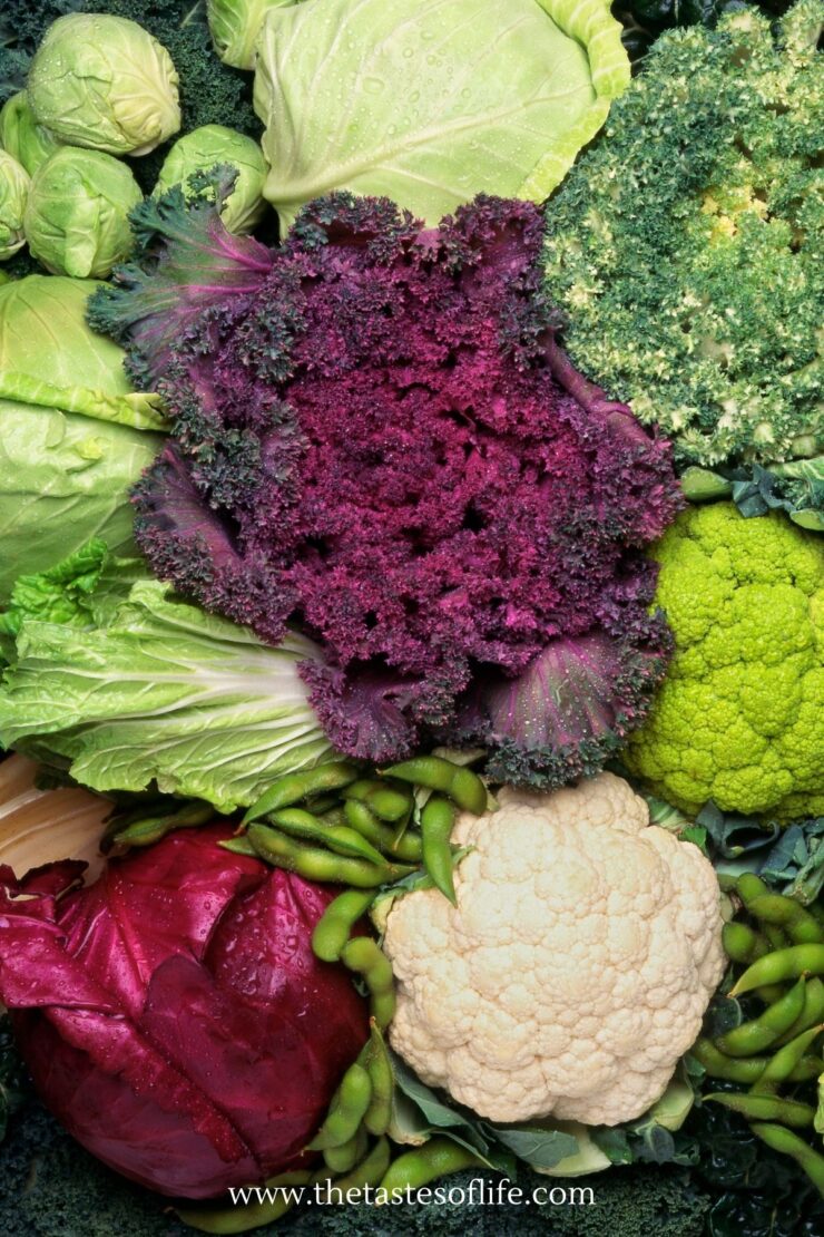 A close-up of assorted vegetables including purple kale, white and green cauliflower, cabbage, Brussels sprouts, and leafy greens. The website www.thetastesoflife.com is visible at the bottom.