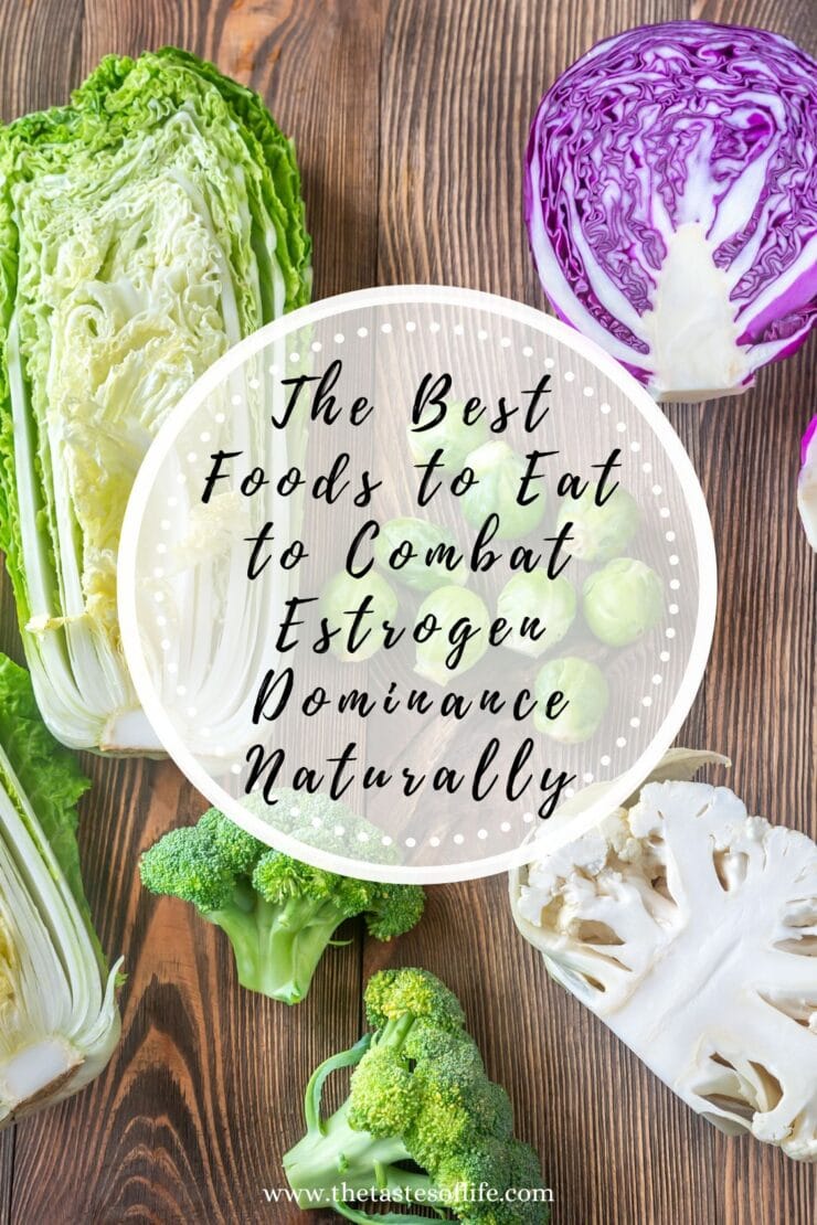 A flat lay of various fresh vegetables including cabbage, red cabbage, cauliflower, and broccoli on a wooden surface with text overlay: The Best Foods to Eat to Combat Estrogen Dominance Naturally.