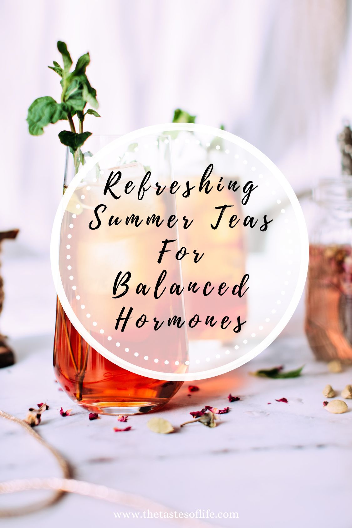 A glass of iced tea with mint leaves and flower petals, surrounded by herbs, with text overlay: Refreshing Summer Teas For Balanced Hormones, perfect for staying cool and supporting your well-being all season long.