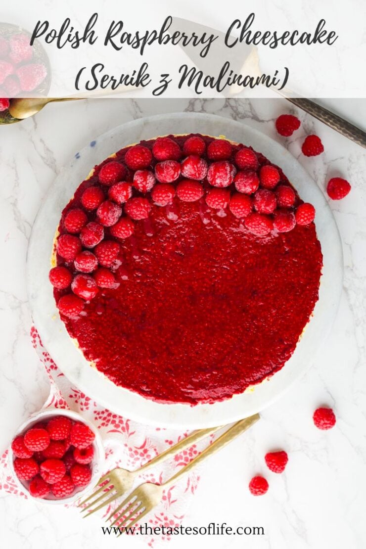 Top view of a Polish raspberry cheesecake garnished with fresh raspberries on a marble surface, with a bowl of raspberries, a gold fork and knife, and a few loose raspberries nearby. Text reads Polish Raspberry Cheesecake (Sernik z Malinami).