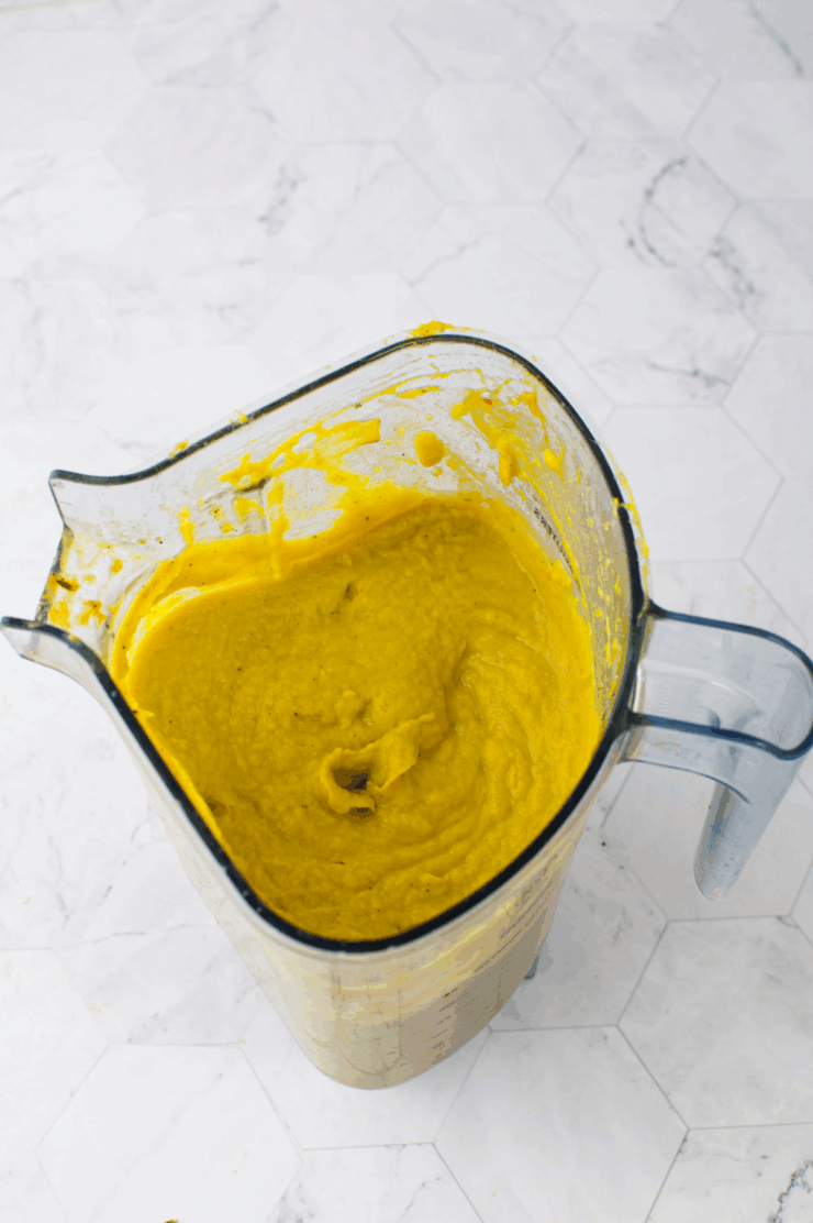 Creamy yellow soup or smoothie in a glass blender pitcher.
