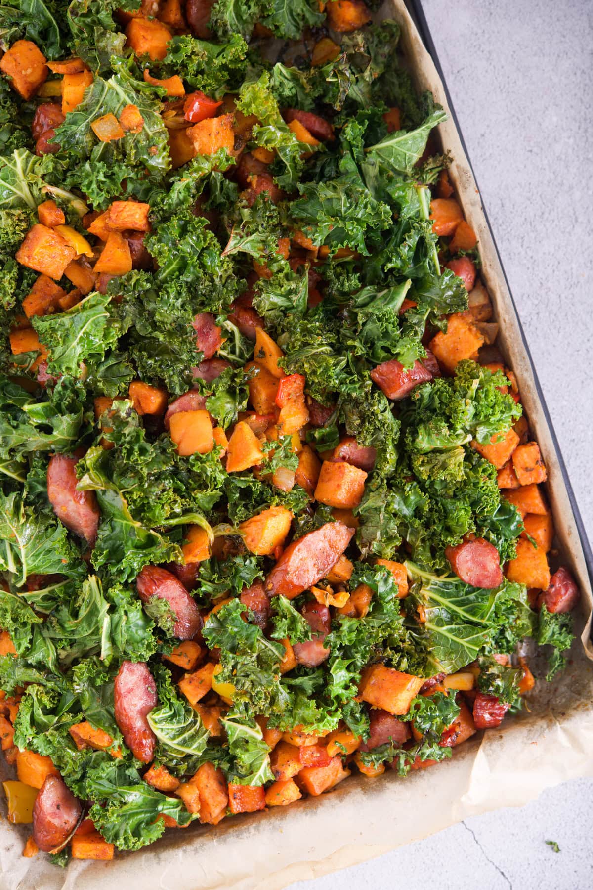 Fresh roasted vegetable and kale casserole in a baking dish.