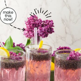 Three glasses of lilac chia seed lemonade with lemon slices and lilac flowers are on a white surface. A bouquet of lilacs, sliced lemons, and a website link are in the background. Text promotes the drink’s taste and simplicity.